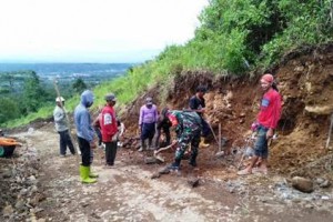 Anggota Koramil Cilimus saat membantu warga perbaiki jalan.